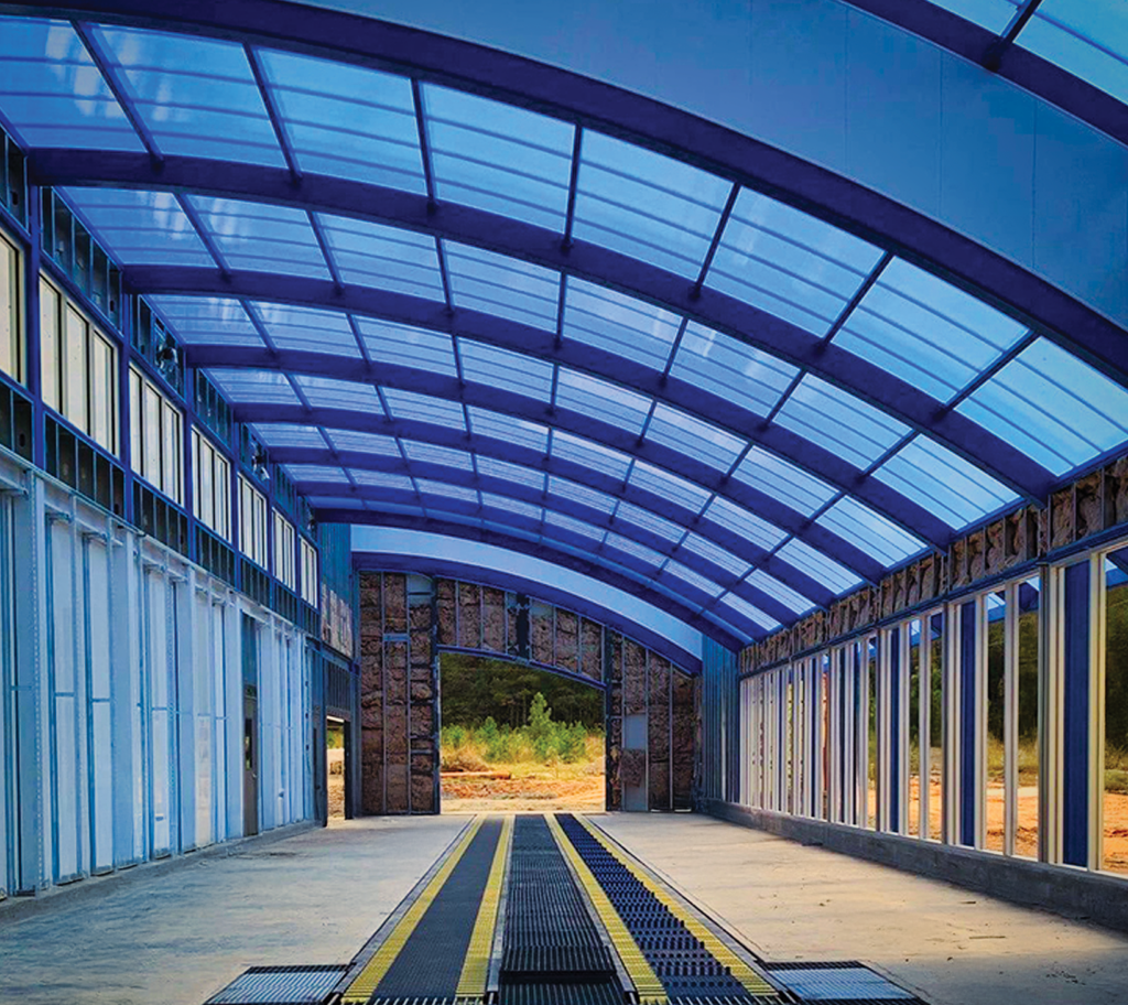 The inside of a drive through car wash has a blue curved Skypoly roof.