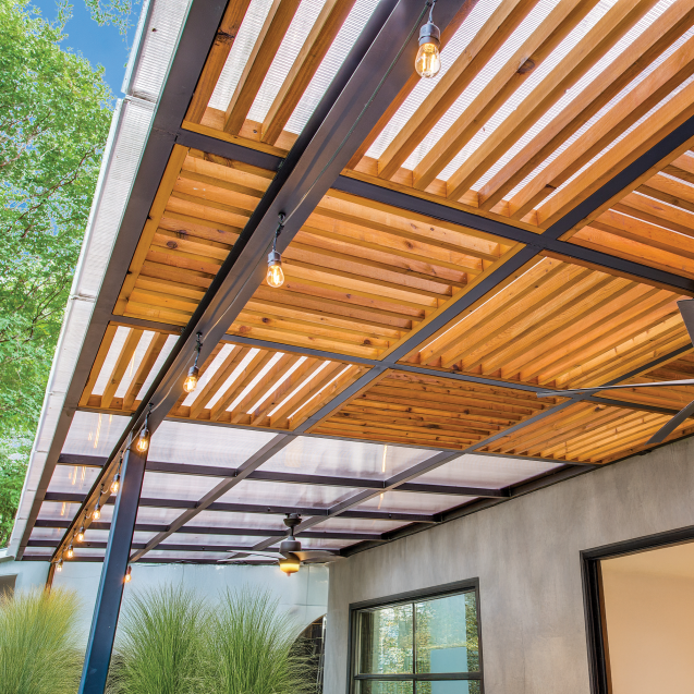 A metal pergola with wooden accent slats is covered with Skypoly Apollo Bronze.