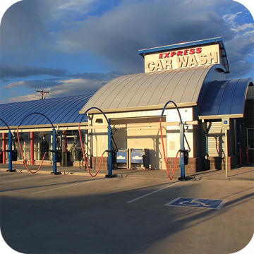 The outside curved roof of a drive through car wash is covered with blue Skypoly with an overlay of tan Skypoly on top.